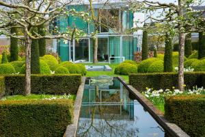 a garden with a pond in front of a building at H-House Architectural Residence in Maastricht