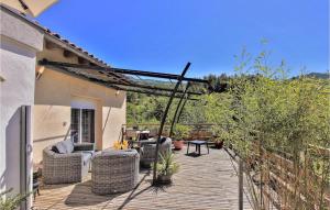 a wooden deck with wicker chairs and a table at 1 Bedroom Lovely Home In Espenel in Espenel