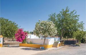 einen Zaun mit einem Baum und rosa Blumen drauf in der Unterkunft 6 Bedroom Cozy Home In Huelva in Huelva