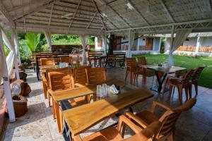 an outdoor restaurant with wooden tables and chairs at the woodland retreat in Dapoli