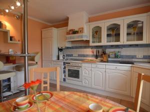 a kitchen with white cabinets and a table and chairs at Luxurious Holiday Home in T nnesberg with Garden in Tännesberg