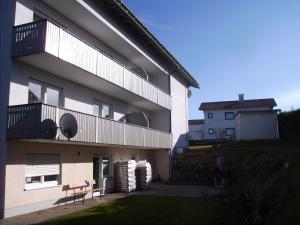 ein Gebäude mit einem Balkon mit einer Bank darauf in der Unterkunft Boutique Holiday Home near Ski Area in Lehen in Lindberg