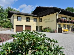 ein großes gelbes Haus mit schwarzem Dach in der Unterkunft Holiday home with sauna near a ski resort in Drachselsried