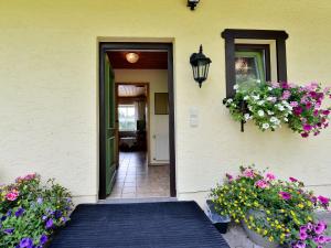 Una puerta a una casa con flores. en Holiday home with sauna near a ski resort, en Drachselsried