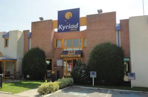 a building with a sign on the side of it at Kyriad Chantilly in Chantilly