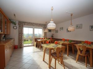 a kitchen and dining room with wooden tables and chairs at Wohnung in Rotthalmünster mit Garten in Andriching