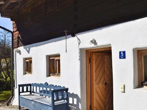 una panchina blu seduta fuori da una casa con una porta di Cozy Holiday Home in Konzell with Terrace a Konzell