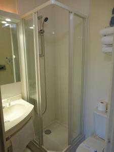 a bathroom with a shower and a toilet and a sink at Kyriad Chantilly in Chantilly