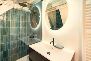 une salle de bain avec un lavabo et deux miroirs dans l'établissement The Hendrik Square Residence, à Anvers 30 autres photos