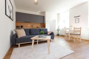a living room with a blue couch and a table at FULL HOUSE Studios - The Buffalo Apartment - WiFi in Zwickau