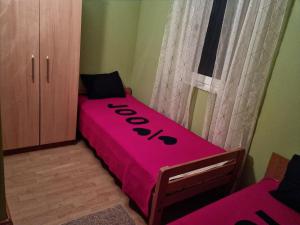 - un lit rose dans une chambre avec une armoire dans l'établissement EMI 1 apartment, à Vir