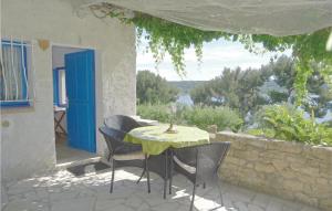 een tafel en stoelen op een patio met uitzicht bij Beautiful Apartment In Istres With 1 Bedrooms, Wifi And Outdoor Swimming Pool in Miramas