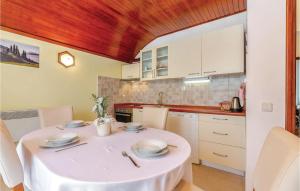 a kitchen with a white table with a white table cloth at Gorgeous Apartment In Dramalj With Wifi in Dramalj
