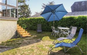 ein blauer Regenschirm, ein Tisch und Stühle sowie ein Tisch mit einem Sonnenschirm in der Unterkunft Nice Home In Hauteville-sur-mer With Wifi in Hauteville-sur-Mer