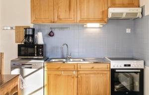 a kitchen with a sink and a stove at Awesome Home In Hauteville-Sur-Mer in Hauteville-sur-Mer