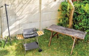 a grill and a picnic table next to a bench at Awesome Home In Hauteville-Sur-Mer in Hauteville-sur-Mer +20 photos