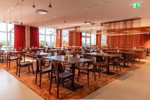 a restaurant with tables and chairs on a rug at Spa Tervise Paradiis in Pärnu