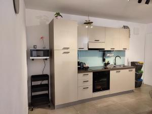 eine Küche mit weißen Schränken und einer Mikrowelle in der Unterkunft Apartment Lucky in Izola