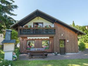 ノイウハウス・アム・レンヴェークにあるCosy holiday home with sauna in the Thuringian Forestのバルコニーとベンチ付きの家