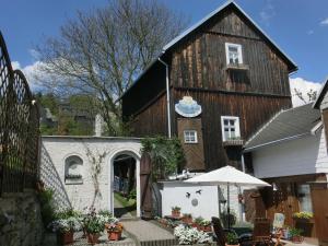 an old barn with a table and an umbrella at Apartment in Thuringian Forest with garden in Oberweißbach