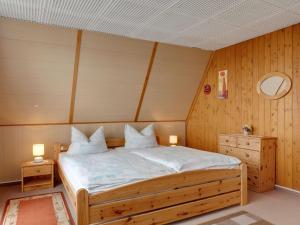 sypialnia z łóżkiem z 2 stolikami nocnymi i 2 lampami w obiekcie Holiday cottage with terrace near the Rennsteig w mieście Bad Liebenstein