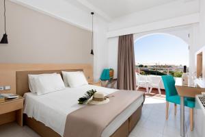 een slaapkamer met een bed en een bureau en een balkon bij Kolymbia Sun in Kolimbia