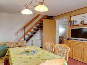 ein Esszimmer mit einem Tisch und Stühlen sowie einem TV in der Unterkunft Holiday cottage with terrace near the Rennsteig in Bad Liebenstein