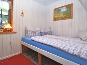 a bedroom with a bed with a blue comforter and a window at holiday home in Langewiesen in Langewiesen