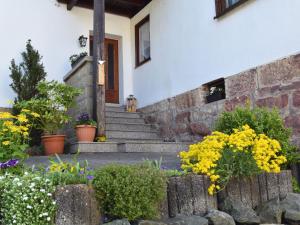 ein Haus mit Treppen und Blumen davor in der Unterkunft Pleasant apartment in Thuringian Forest with garden in Kurort Steinbach-Hallenberg