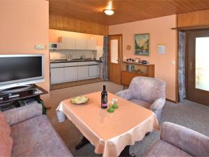 a living room with a table and a television at Holiday home near the Schwarza Valley in Grossbreitenbach