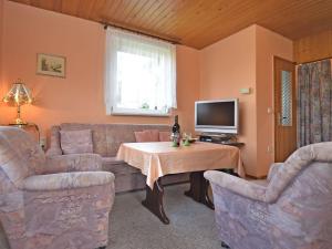 ein Wohnzimmer mit einem Sofa und einem Tisch in der Unterkunft Holiday home near the Schwarza Valley in Grossbreitenbach