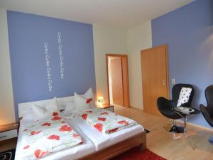 a bedroom with a bed and a chair in it at Romantic apartment in Ilmenau in Langewiesen