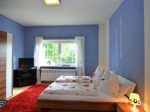 a blue bedroom with a bed and a window at Romantic apartment in Ilmenau in Langewiesen