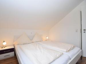 uma cama branca com duas almofadas em cima em Beautiful Apartment in Willingen with a Balcony em Willingen