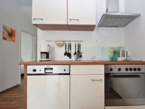 a kitchen with white cabinets and a counter top at Beautiful Apartment in Willingen with a Balcony in Willingen