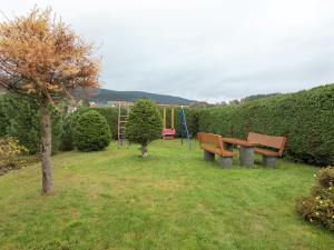 a park with two park benches and a playground at Holiday home with garden in Altenfeld