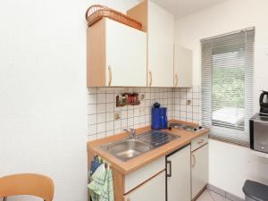 a small kitchen with a sink and a microwave at Holiday home with garden in Altenfeld