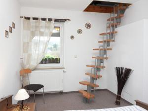 Habitación con escalera de caracol y ventana en Holiday home with garden, en Altenfeld