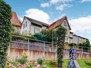 a home with a ivy covered fence and houses at Holiday home with garden in Langenbach