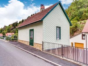a small white house with a red roof on a street at Holiday home with garden in Langenbach