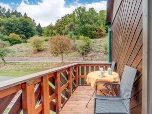 a wooden balcony with a table and chairs on it at Holiday home with garden in Langenbach