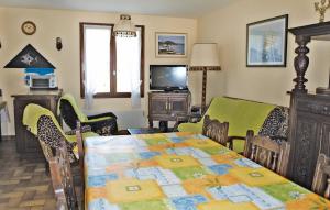 KerlouanにあるStunning Home In Kerlouan With 3 Bedroomsのダイニングルーム(テーブル、椅子、テレビ付)