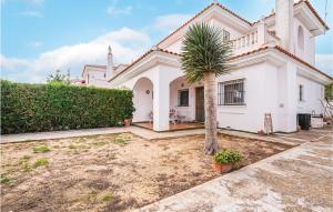 a white house with a palm tree in the yard at 3 Bedroom Nice Home In Matalascañas in Matalascañas