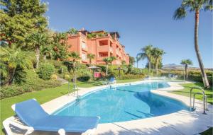 uma piscina com uma cadeira azul e um edifício em Royal Los Flamingos em Estepona