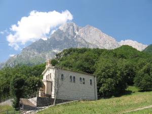 a building on a hill with a mountain in the background at Hotel Casale in Isola del Gran Sasso dʼItalia
