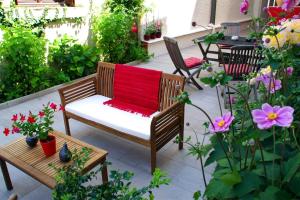 d'une terrasse avec un banc et une couverture rouge. dans l'établissement Hôtel Mille et une Feuilles, à La Charité-sur-Loire