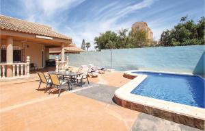 卡塔赫納的住宿－Cozy Home In Cartagena With Kitchen，游泳池旁带桌椅的天井