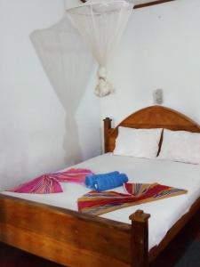 a bedroom with a bed with two umbrellas on it at Bandula Home Stay in Sigiriya