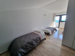 a bedroom with two beds in a room with a wooden floor at Apartamento Numi II in L'Ametlla de Mar +4 photos