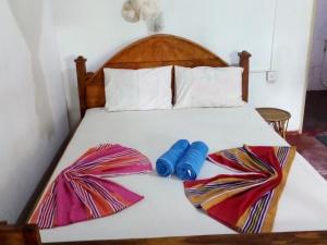 1 dormitorio con 1 cama con 2 toallas en Bandula Home Stay, en Sigiriya